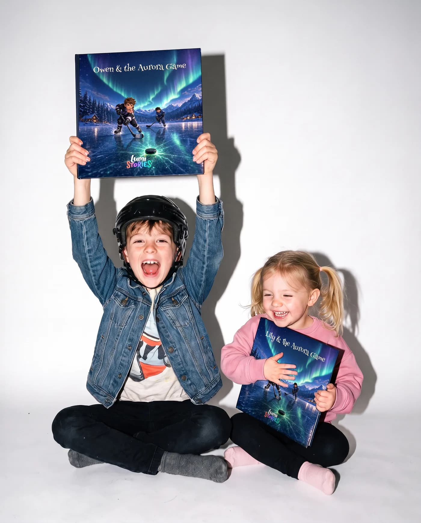 Two siblings on a white studio backdrop, each holding their own copy